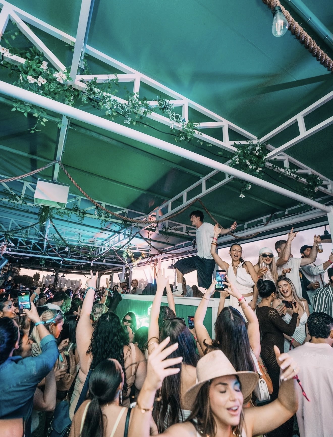 Palm Tree Club Miami crowd DJ stage green canopy