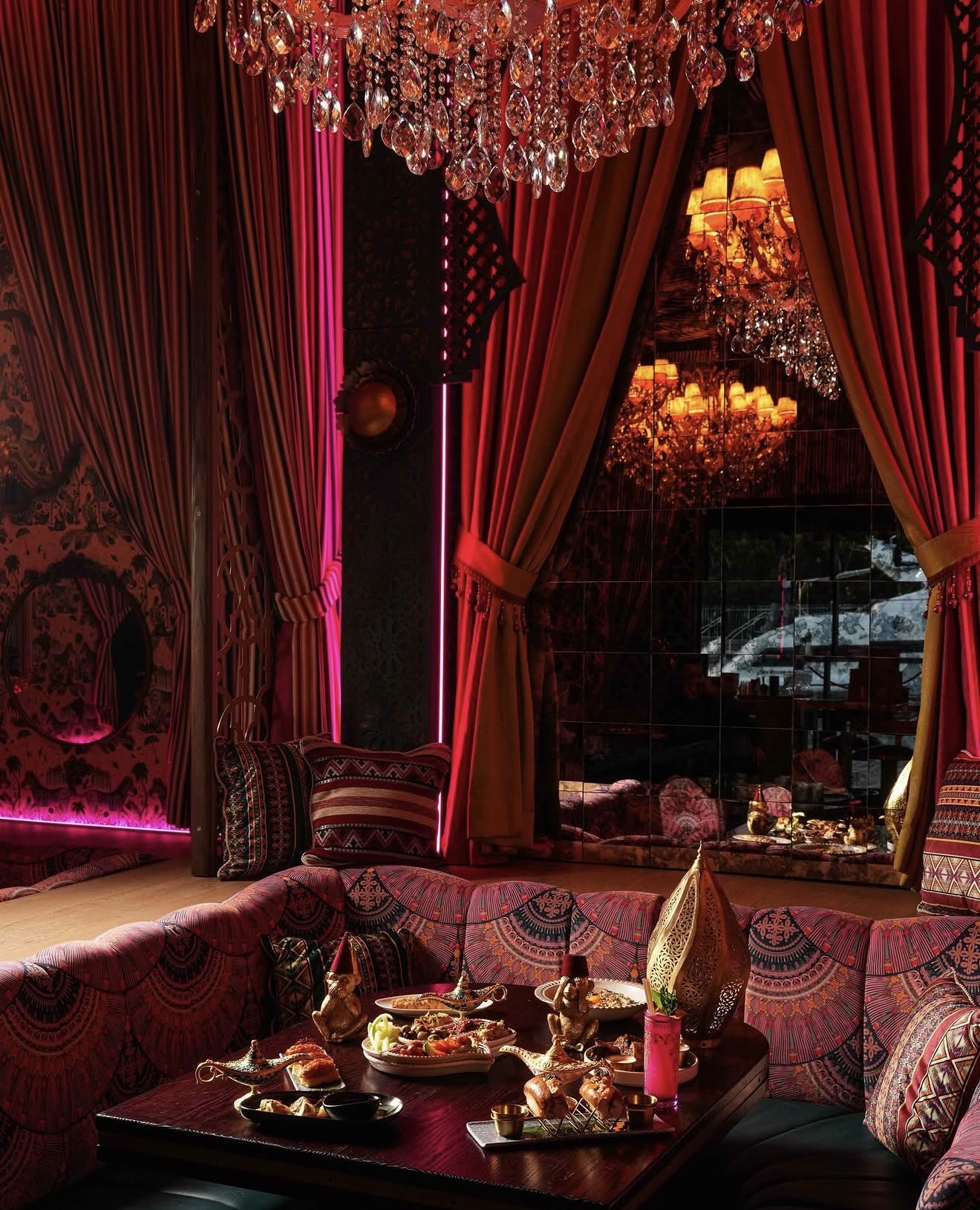 Habibi Miami River private booth velvet cushions Arabian decor crystal chandelier red drapes food spread Miami River restaurant Habibi Miami River private booth velvet cushions Arabian decor crystal chandelier red drapes food spread Miami River restaurant