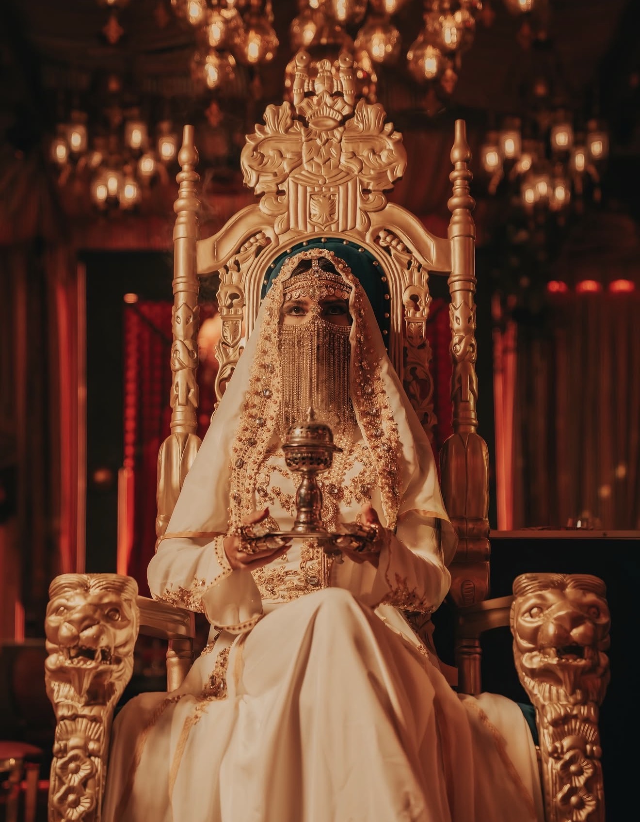 Habibi Miami River costumed performer gold throne Arabian headdress veil chandelier backdrop Miami River restaurant Habibi Miami River costumed performer gold throne Arabian headdress veil chandelier backdrop Miami River restaurant